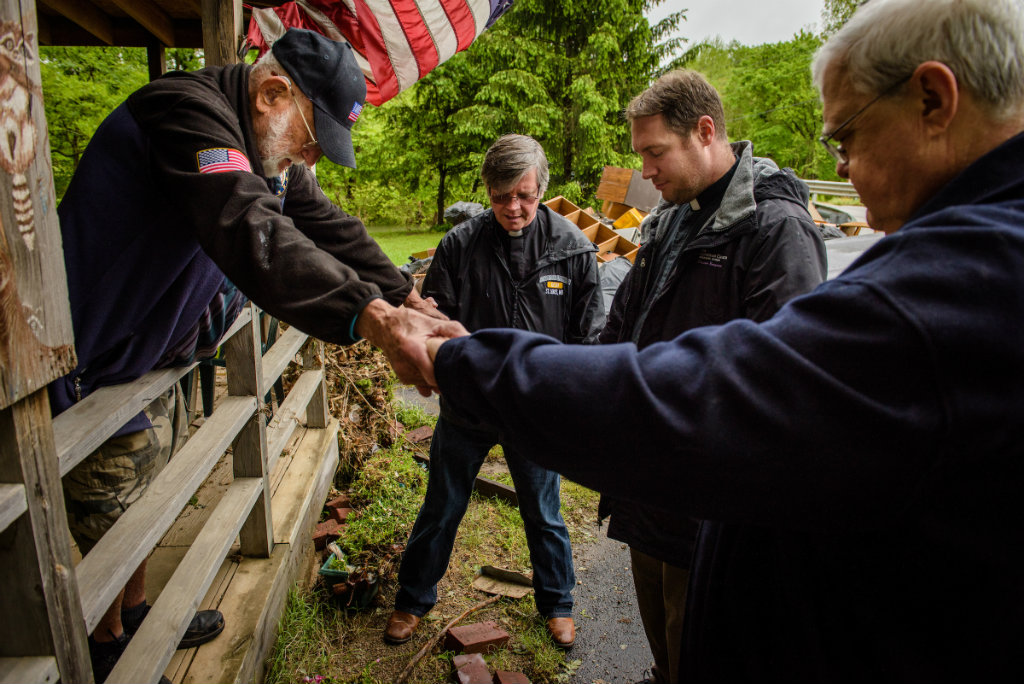 Dick Keezer (left), a church member and flood victim, prays with his pastor, the Rev. Steve Gillmore (center) of First Lutheran Church, Neosho, Mo., the Rev. Michael Meyer, manager of LCMS Disaster Response, and the Rev. Greg Mech (right), pastor of Immanuel Lutheran Church, Joplin, Mo., during a visitation with Keezer at his flood-damaged home on Wednesday, May 3, 2017, in Neosho. LCMS Communications/Erik M. Lunsford