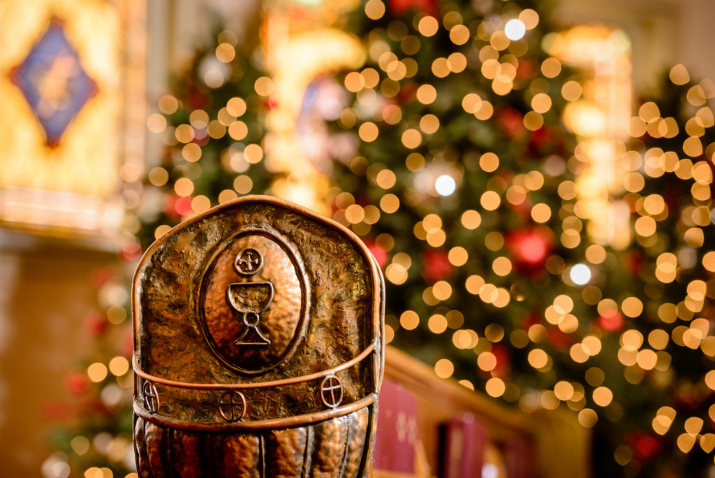 A handmade holder on a pew used for the disposal of individual communion cups is framed by Christmas trees at Holy Cross Lutheran Church, Collinsville, Ill., on Monday, Nov. 27, 2017. LCMS Communications/Erik M. Lunsford